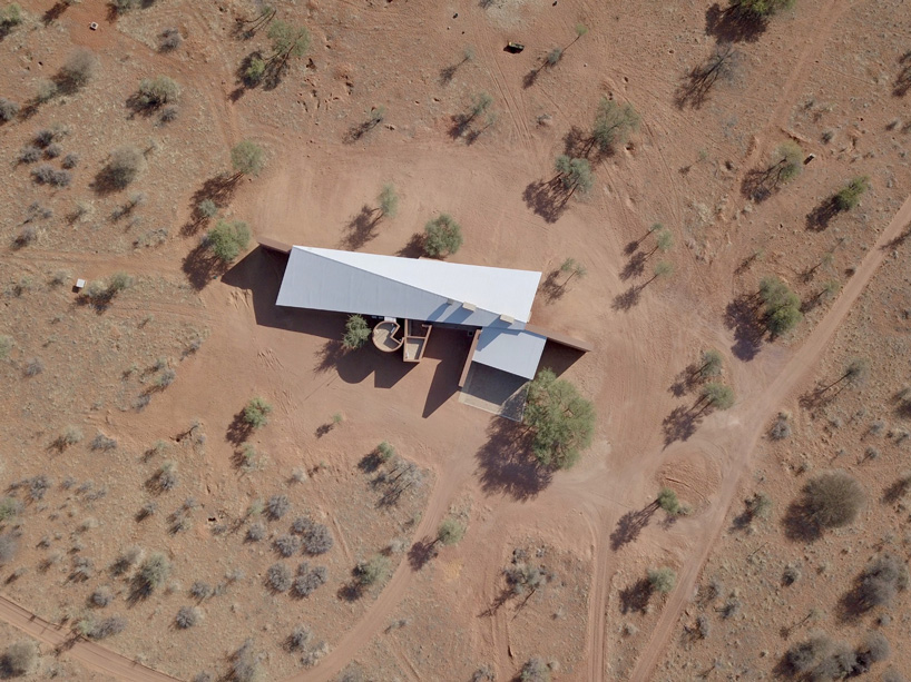 slee & co. architects' red earth hunting lodge emerges from the namibian landscape