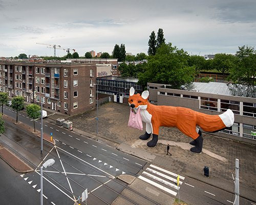 florentijn hofman's gigantic fox wanders through the grey streets of rotterdam