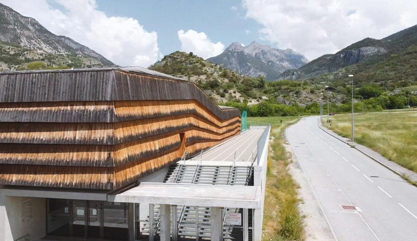larch cladding folds over gymnasium guillestre to echo the landscape designboom