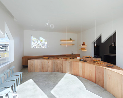 airhouse completes 'bakery tsukiakari' in japan with half-moon wooden counter 