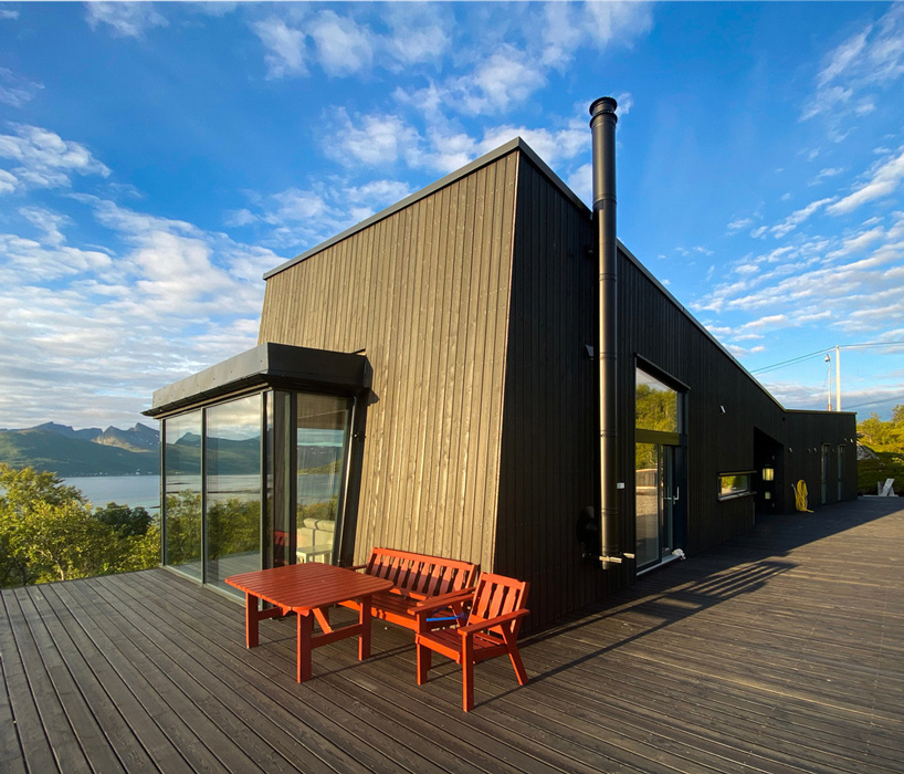 the cabin is wrapped in a wood façade painted in dark grey