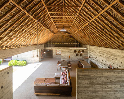 dried palm tree leaves and local wood form roof of vacation house in mexico