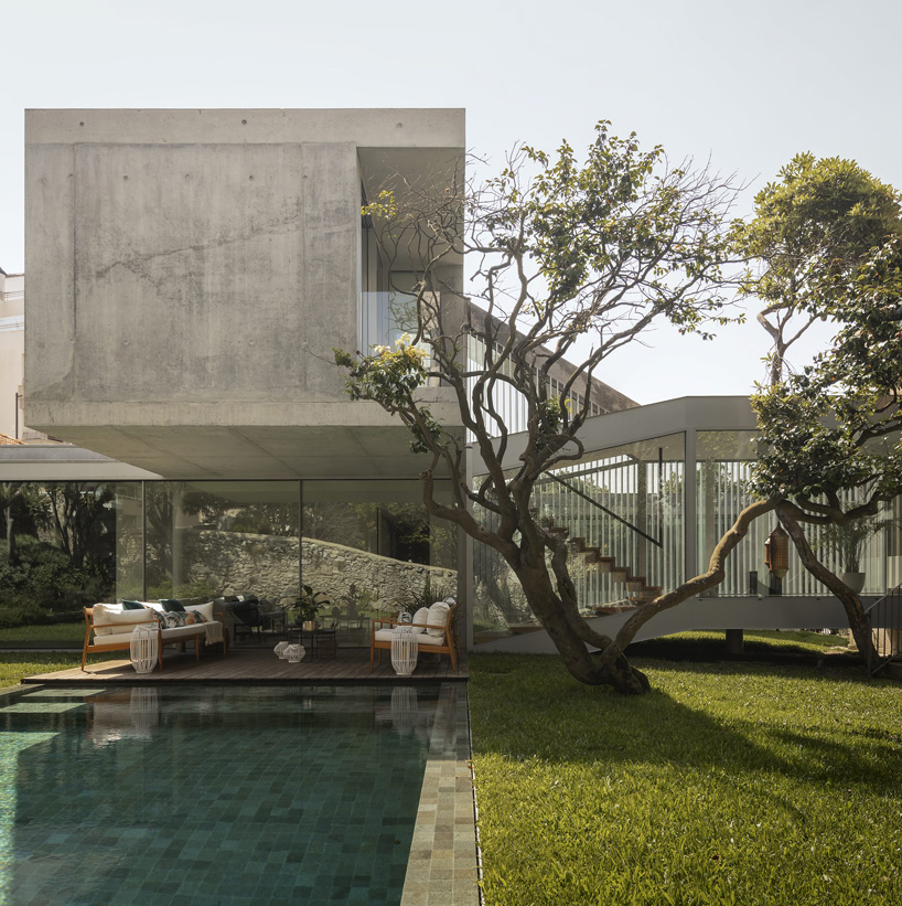 a concrete volume cantilevers above the house's pool