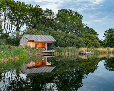 oak wood cladding + concrete details build lake cabin by RX architects in the UK
