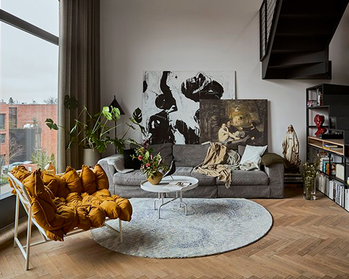 a steel staircase doubles as storage in this poznan apartment designed by UGO