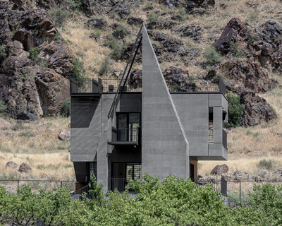 'gray villa' by white cube atelier draws from iran's irregular rocks + mountains