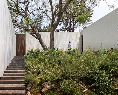 manuel cervantes estudio realizes white ceramic house with jacaranda garden in mexico
