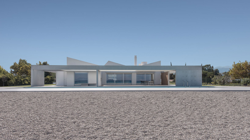 r.c. tech's white monolithic beach house sits by the coast of northern peloponnese, greece