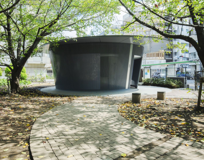 tadao ando contributes to the tokyo toilet project with a cylindrical, louvred volume