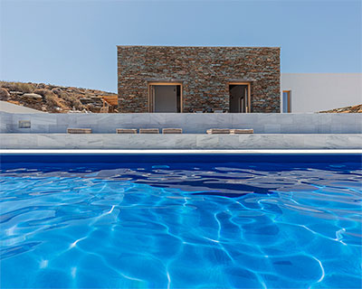 whitewashed & stone-clad cubic volumes form holiday house in sifnos island, greece