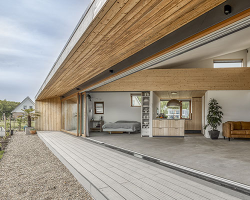 large sliding door merges exterior & interior of 'south house' in the netherlands