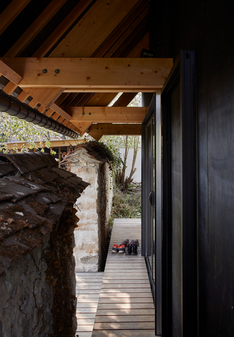 arba builds a timber house between two old stone walls in rural france - 3