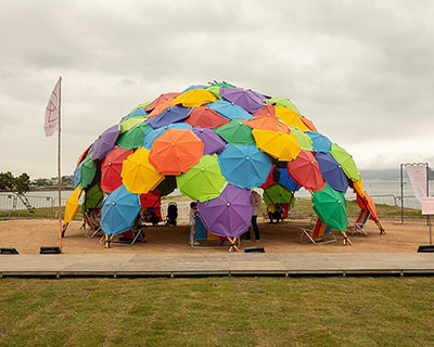 dome installation made out of colorful umbrellas decorates beach on brazil