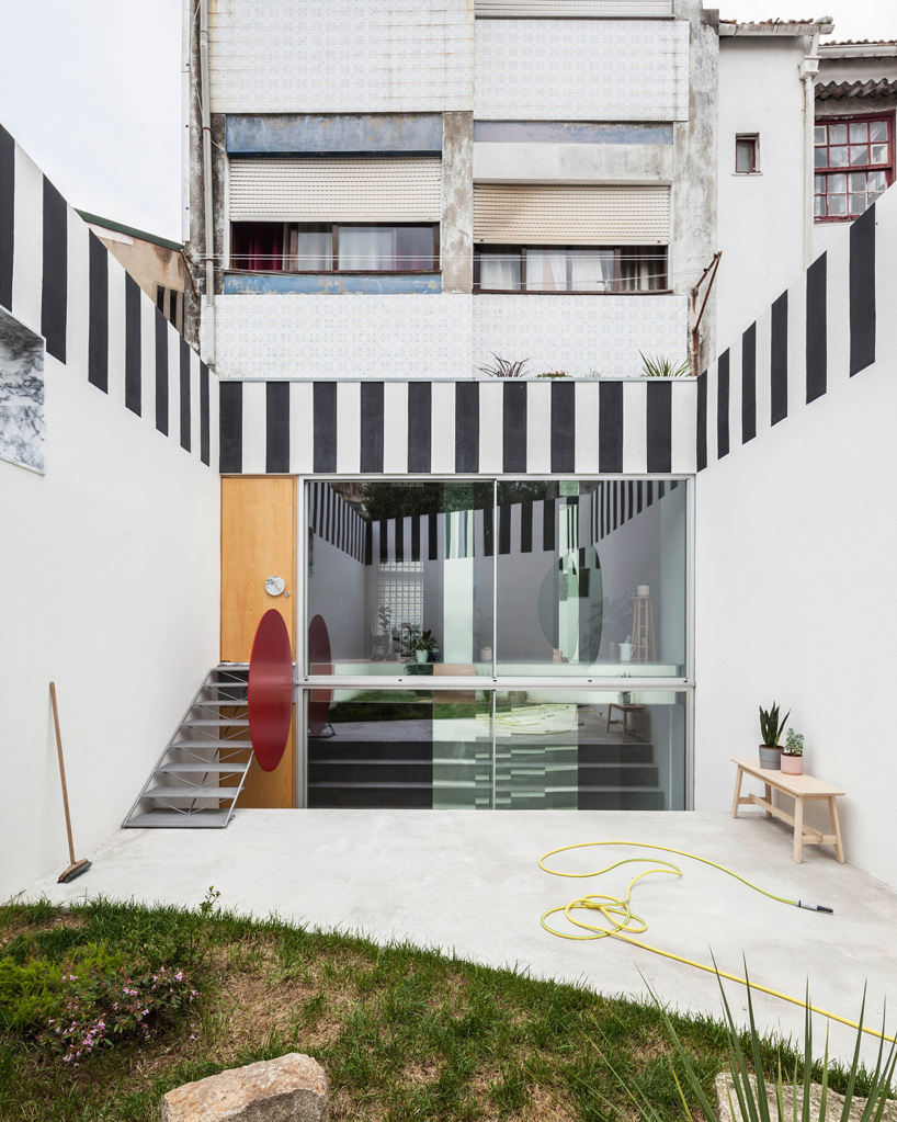 fala atelier uses black + white stripes to frame 'uneven house' in porto