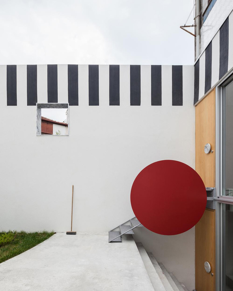 large red disk acts as a handle for the stairs in fala atelier's 'uneven house'