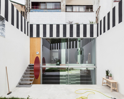 fala atelier uses black + white stripes to frame 'uneven house' in porto