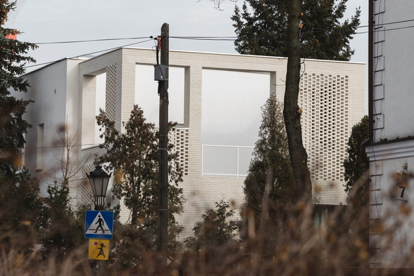 MFRMGR architects adds perforated white-brick frame to 1970s terrace house in poland