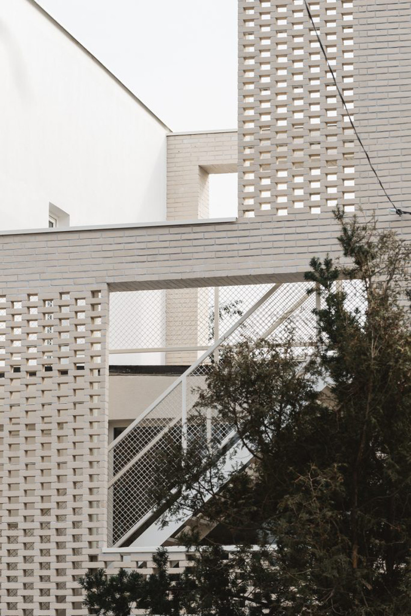 MFRMGR architects adds perforated white-brick frame to 1970s terrace house in poland