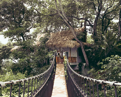 VIDA designs ranch house with suspension bridge within costa rica tropical forest