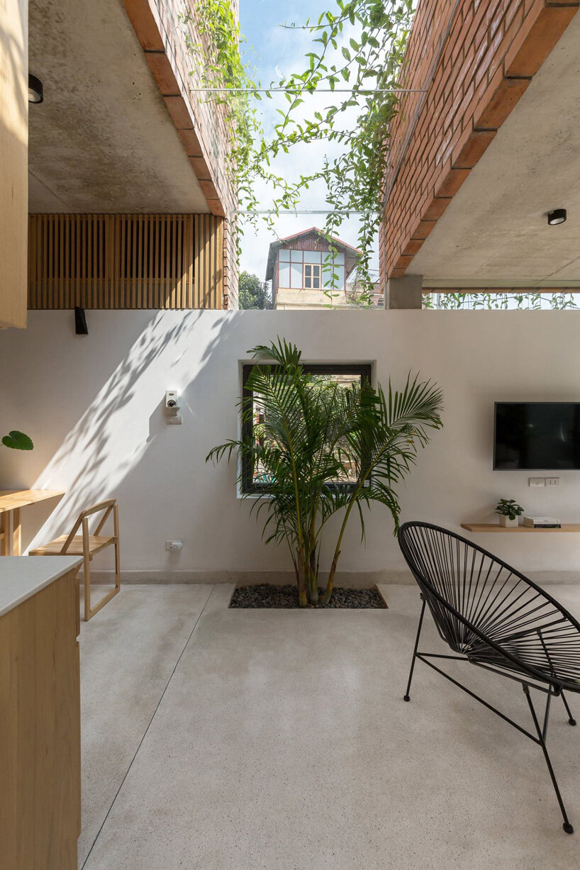 ODDO architects incorporates round window into the brickwork of VH house in hanoi