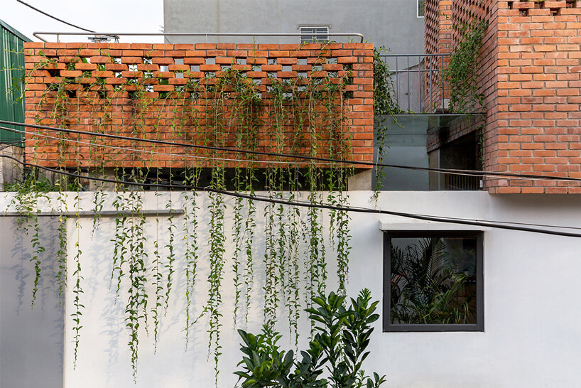 ODDO architects incorporates round window into the brickwork of VH house in hanoi