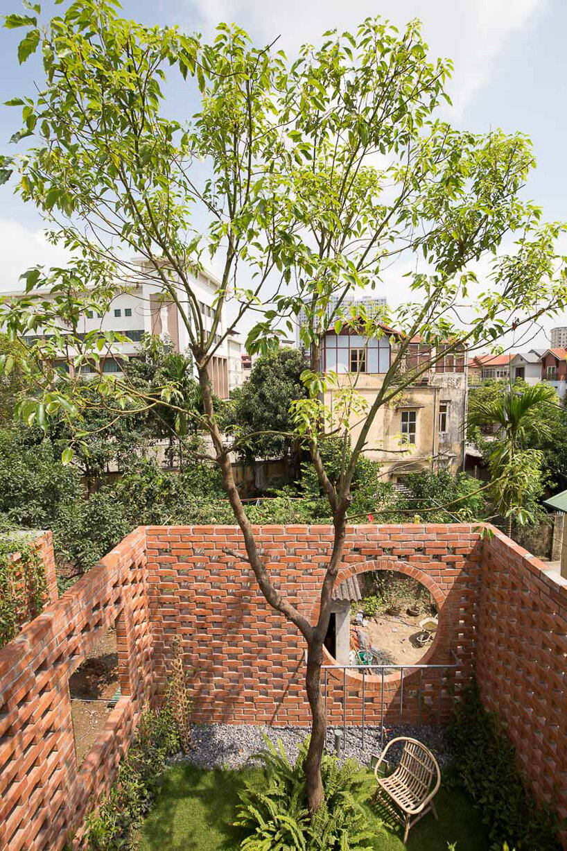 ODDO architects incorporates round window into the brickwork of VH house in hanoi