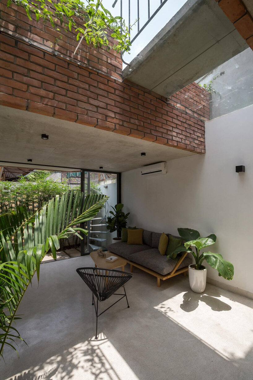 ODDO architects incorporates round window into the brickwork of VH house in hanoi