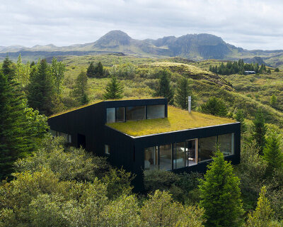 KRADS tops holiday home in iceland with green roof that blends with the landscape
