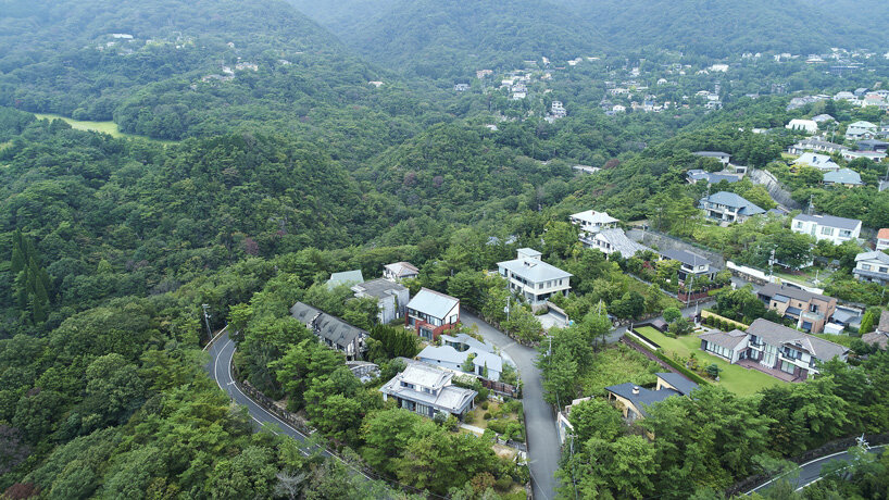 sculptural roof curves around growing trees in tomohiro hata's house in okuike, japan