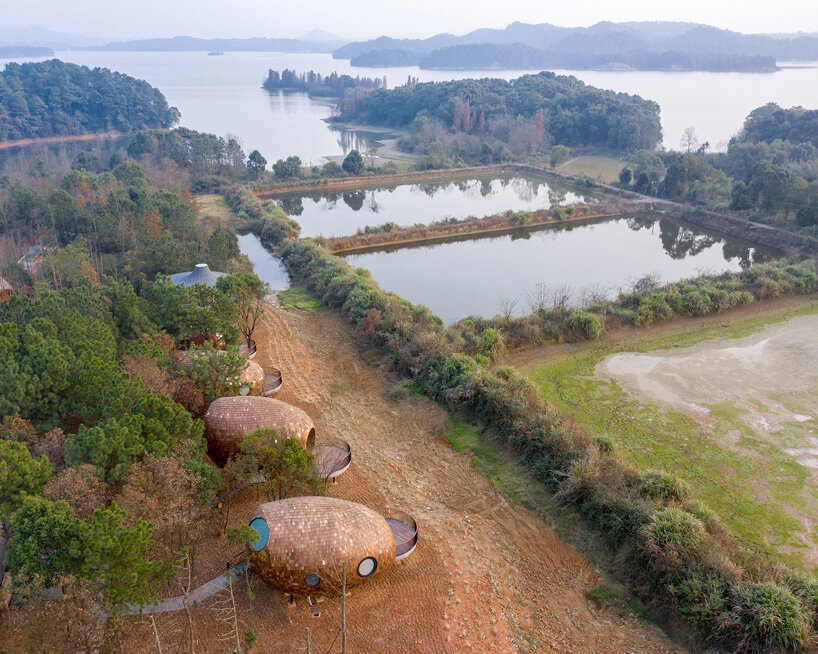 ZJJZ clads ellipsoidal guest houses in mirrored aluminum + pine shingles in rural china