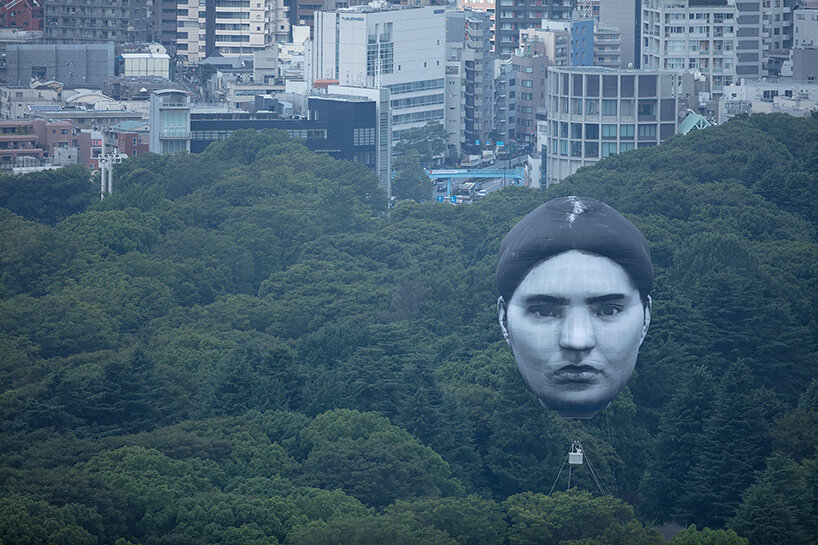 giant balloon head floats over tokyo