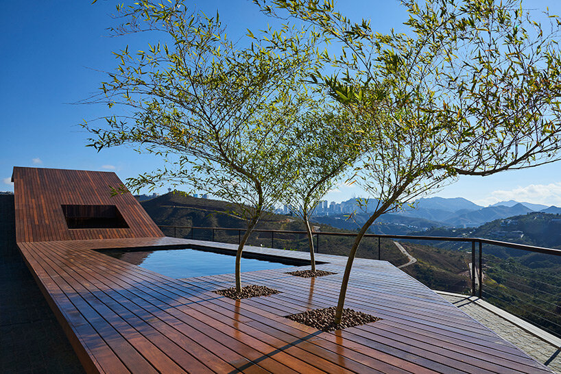 tetro tops residence with irregular deck roof opening towards mountainous views in brazil