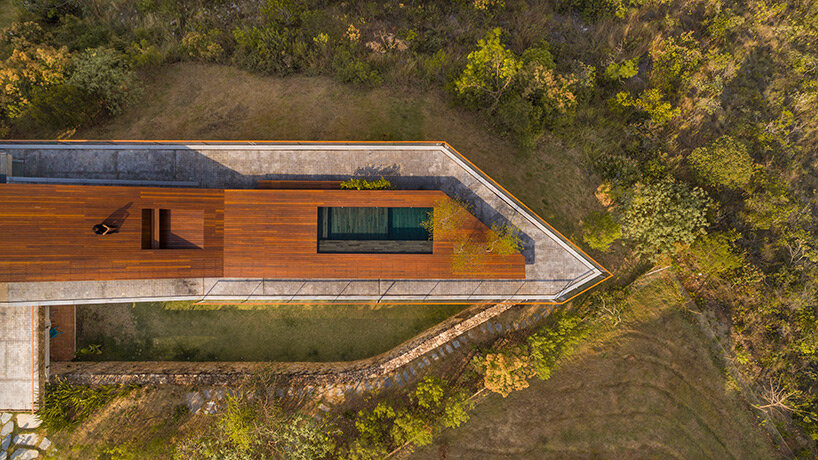 tetro tops residence with irregular deck roof opening towards mountainous views in brazil