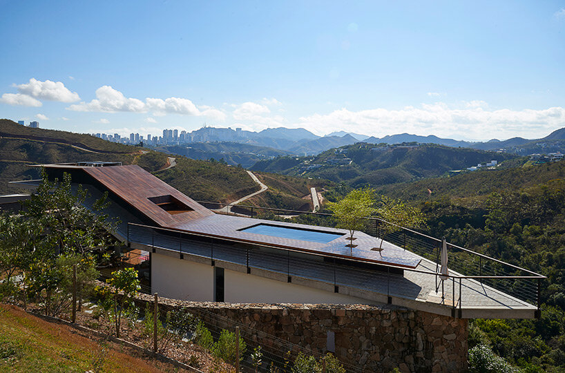 tetro tops residence with irregular deck roof opening towards mountainous views in brazil