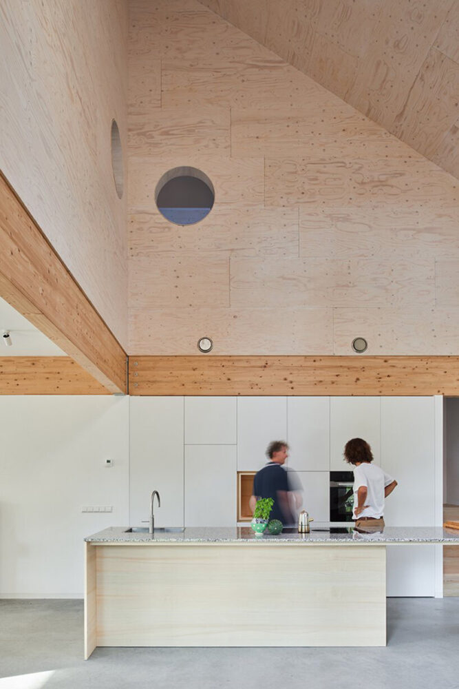 De wand van de stofzuiger wordt omlijst door twee ronde randen, die een visuele verbinding creëren tussen de keuken en de bovenverdieping.
