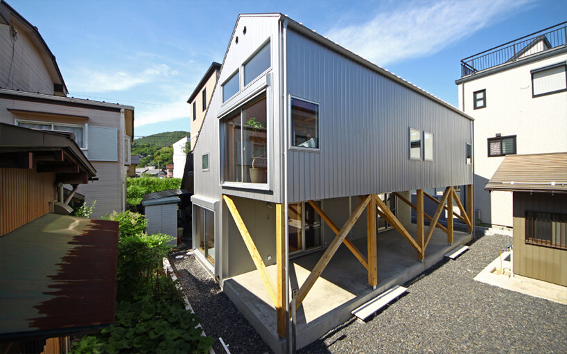 midorichio house in japan emerges from wooden skeleton forming a piloti