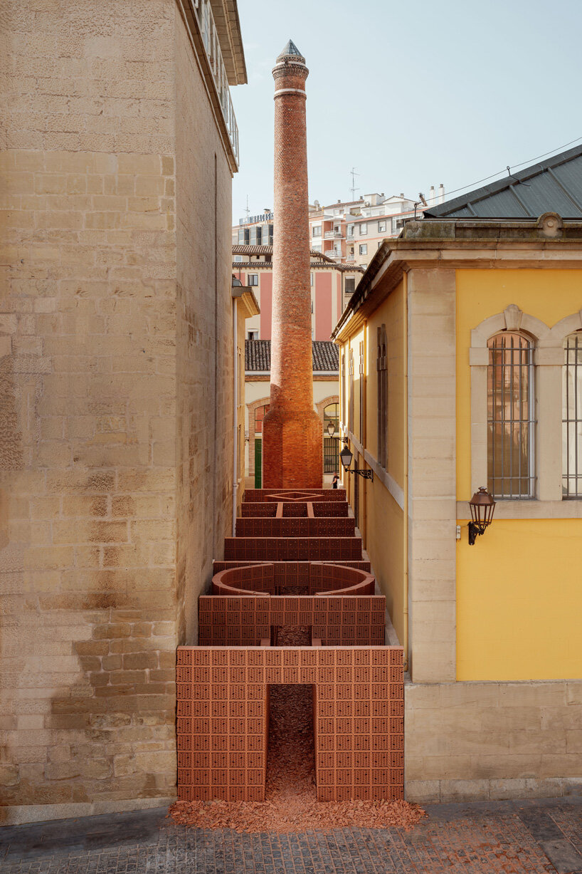 PALMA + hanghar insert temporary brick pavilion in an old factory's narrow passage in spain