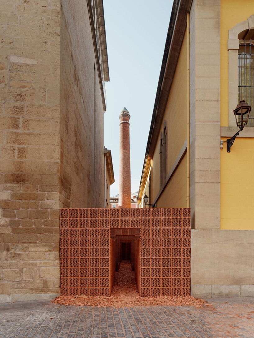 PALMA + hanghar insert temporary brick pavilion in an old factory's narrow passage in spain
