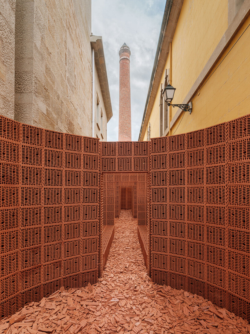 PALMA + hanghar insert temporary brick pavilion in an old factory's narrow passage in spain