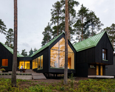 pirinen & salo sets three-volume charred wood house between pine trees in finland