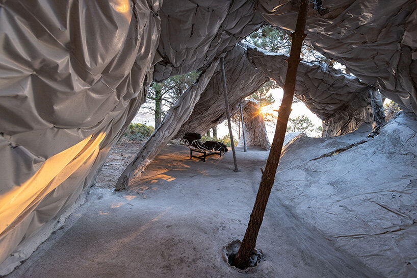 ensamble studio shapes the tent as a blanket that covers the space in spain