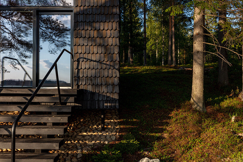 pirinen & salo clad the filmmakers hut in finland with tar-coated shingles