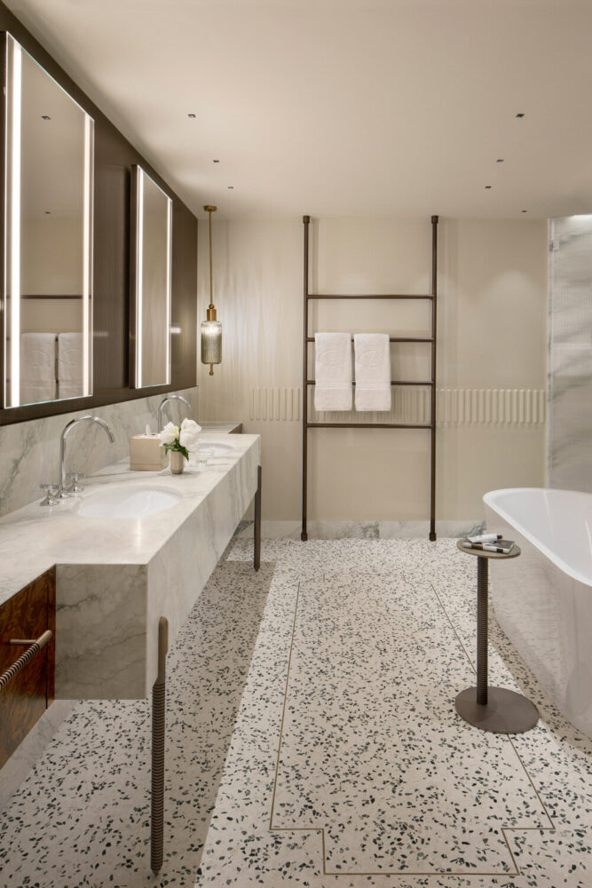 in the bathrooms, calm, natural, tone-on-tone colors are punctuated by accents of dark wood and burnished brass