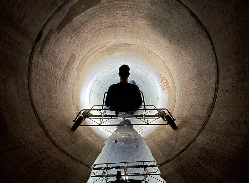 a bike inside a tunnel: artist fernando abellanas pedals through a sewer with ‘enlace’