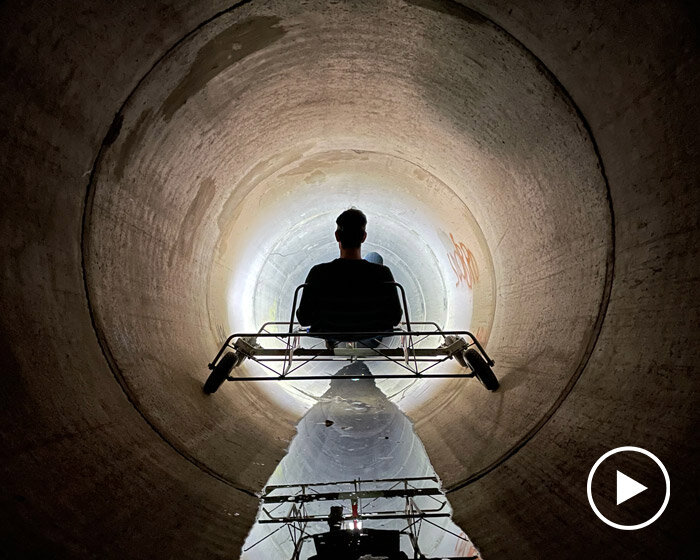 a bike inside a tunnel: artist fernando abellanas pedals through a sewer with ‘enlace’