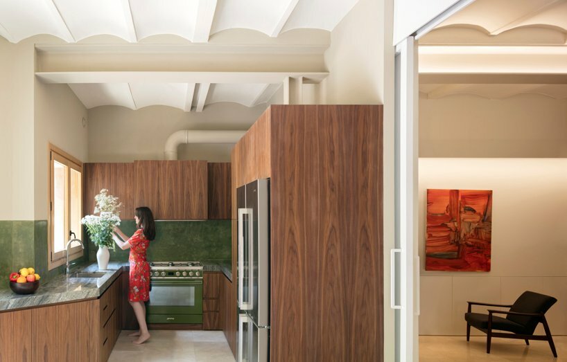 the kitchen is connected to the living space trough a sliding door and receives a warm and bright light from the garden