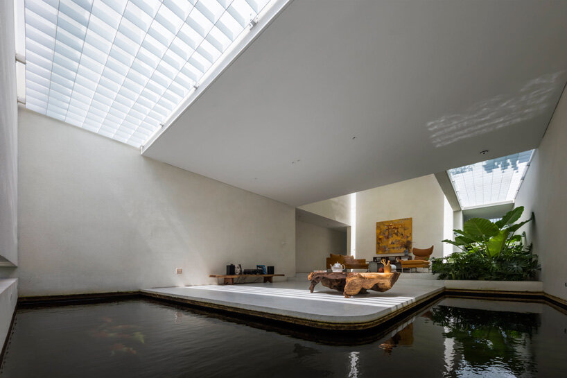 interior fish pond surrounds the living area of 23o5 studio's serene house in vietnam