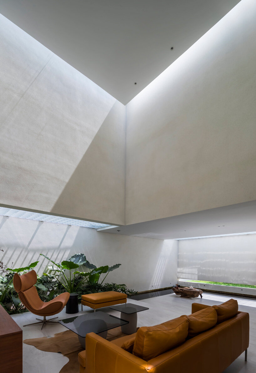 interior fish pond surrounds the living area of 23o5 studio's serene house in vietnam