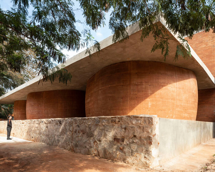 these toilets at paraguay's university of asunción are a cluster of rammed-earth boulders