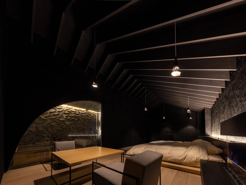 kengo kuma adds local stone to hot spring inn in kusatsu, japan